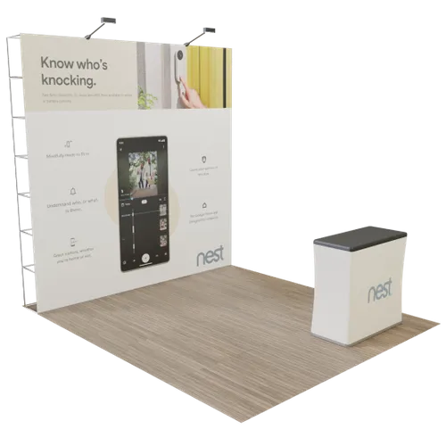 Exhibit display with promotional graphics, featuring a desk and a backdrop with text and images, likely for a trade show. Text: 'Know who's knocking.' - 'nest'.